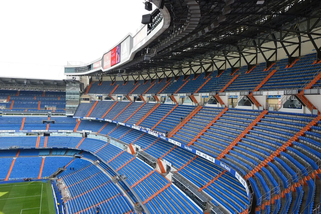Tomt stadion med blå og orange tribuner